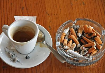 杯咖啡濃咖啡和煙灰缸的煙頭完全正確
