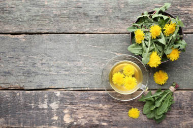 黃蒲公英配杯茶在灰木桌上