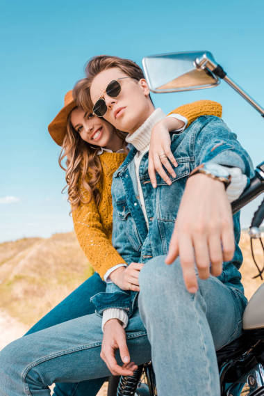 坐在草地上的老式摩托车微笑夫妇