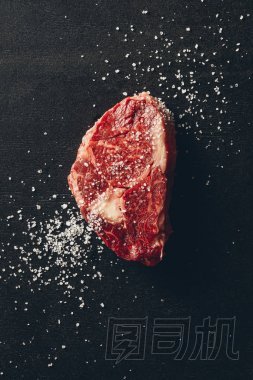 廚房表面生肉牛排和鹽的頂部視圖