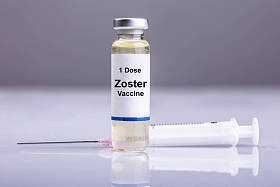 带注射器的带状疱疹疫苗瓶在反光背景下
