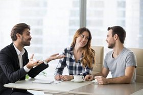 愉快的夫妇在谈话时激动与代理在办公室