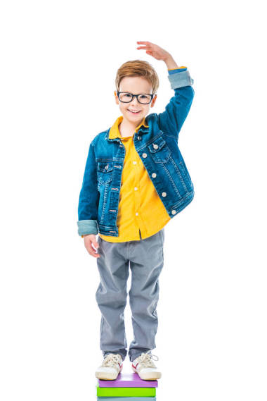 小學(xué)生站在一堆書要高, 孤立的白色 