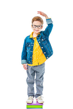 小学生站在一堆书要高, 孤立的白色 