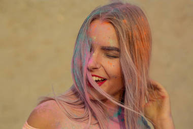 特寫肖像的笑金發(fā)女郎與紅唇玩橙色干漆在沙漠