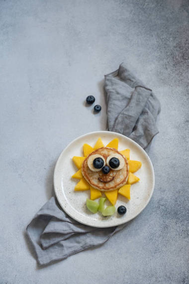 给孩子们吃的带有浆果的有趣的花煎