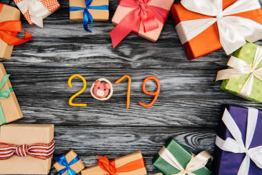 2019年標(biāo)志的頂部視圖和包裝在木表面的圣誕禮物