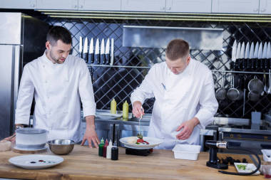 在厨房一起工作的年轻厨师照片