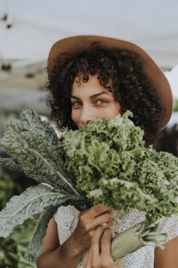 在农民市场上买甘蓝的漂亮女人