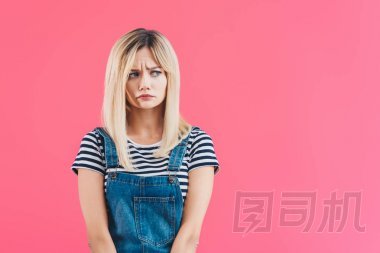 擔心美麗的女孩牛仔整體看著遠離粉紅色的孤立