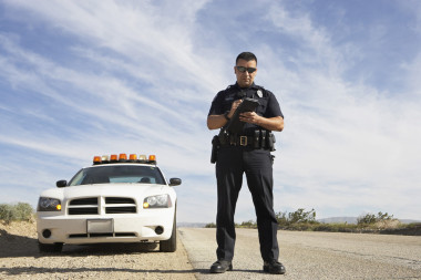 警務(wù)人員在車前面記筆記圖片