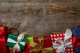 平躺与礼物包裹在不同的包装纸与丝带在木背景