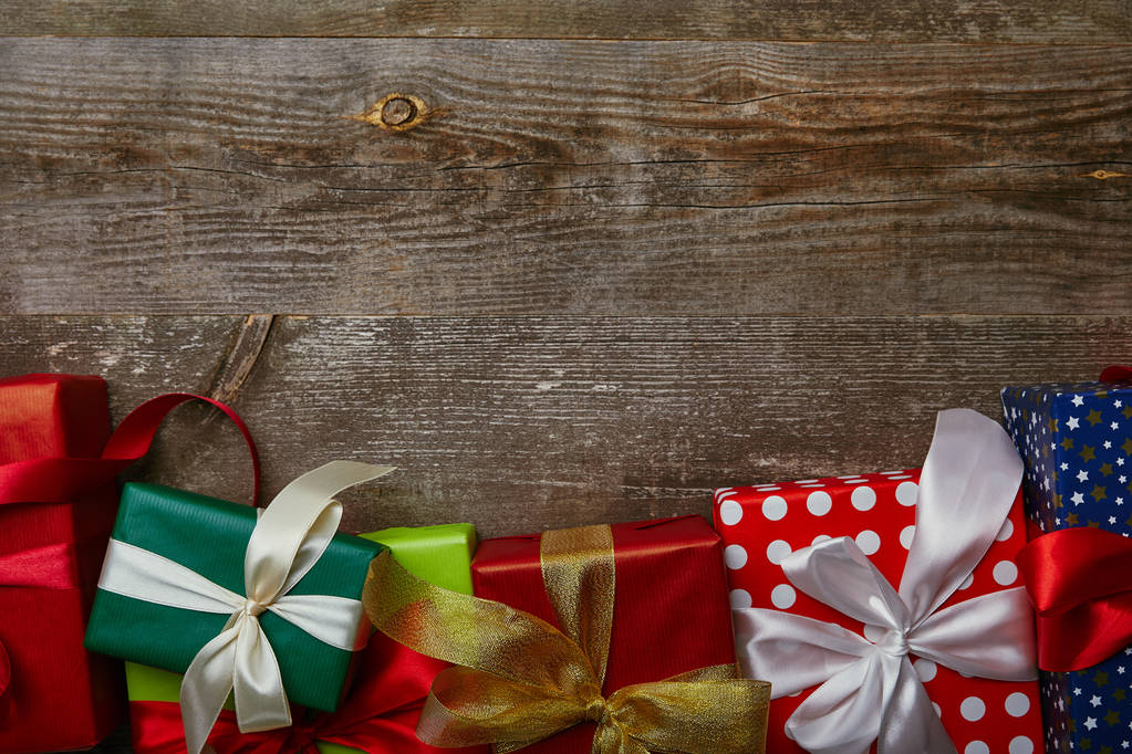 平躺与礼物包裹在不同的包装纸与丝带在木背景 平躺与礼物包裹在不同的包装纸与丝带在木背景