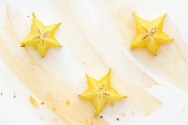 黃色水彩對(duì)白色表面三顆甜星果實(shí)的高觀