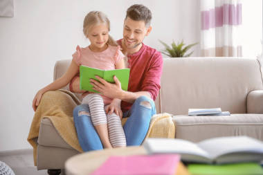 父亲在家做家庭作业的小女孩照片