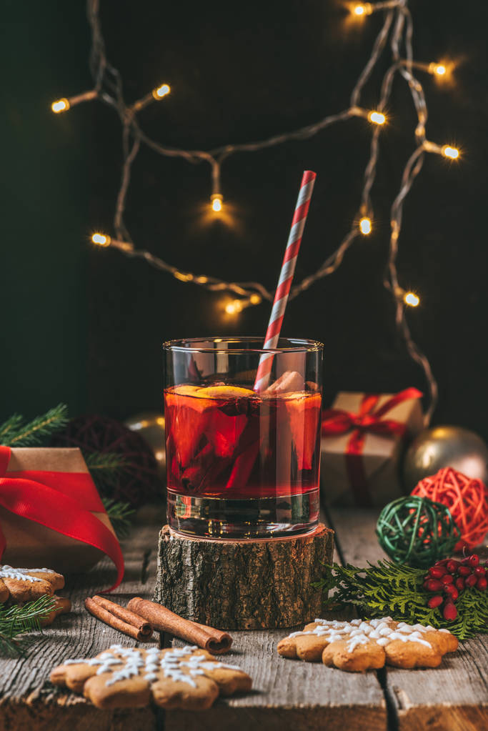 用姜饼和圣诞灯花环在木树桩上的酒杯