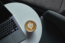 咖啡桌上的咖啡杯和笔记本电脑的顶部视图