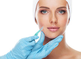 美丽的脸的年轻女子和医疗手术刀在医生的手被孤立的白色。整形外科、美容医学与人脸提升理念