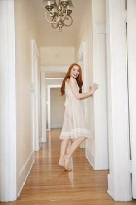 有吸引力的年轻女性站在走廊的全长