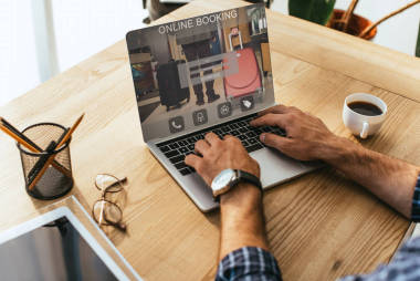 在桌面上使用在線預(yù)訂的筆記本電腦上的商人的部分看法