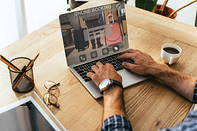 在桌面上使用在线预订的笔记本电脑上的商人的部分看法