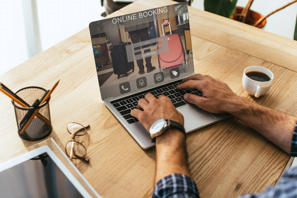 在桌面上使用在线预订的笔记本电脑上的商人的部分看法 在桌面上使用在线预订的笔记本电脑上的商人的部分看法