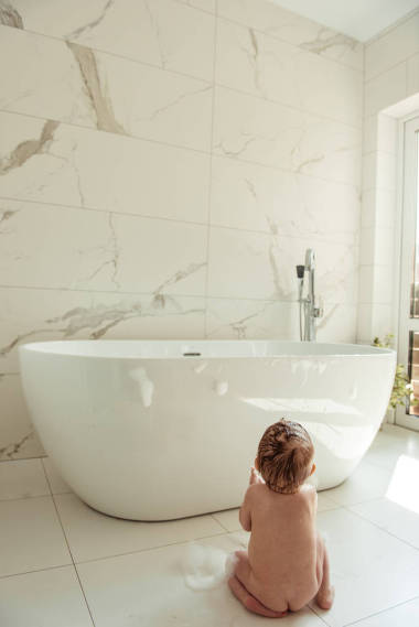 愉快的小男孩在浴室地板上