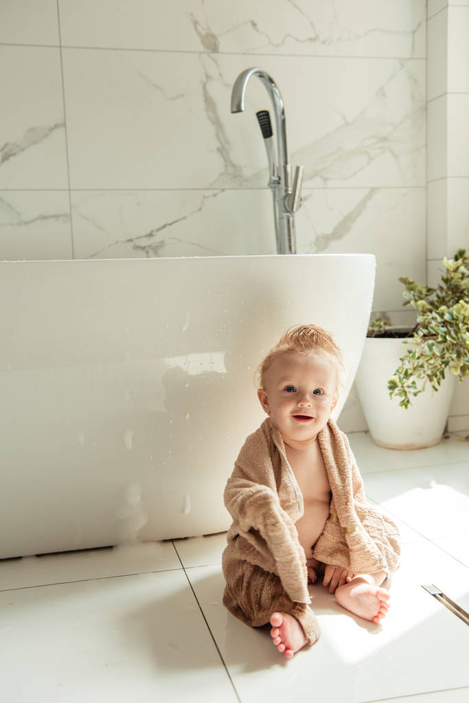 愉快的小男孩在浴室地板上图片 愉快的小男孩在浴室地板上图片