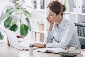 专注自信的女实业家在现代办公室与笔记本电脑工作
