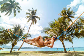 夏日假期的概念, 穿着泳装的女人在巴拉望岛的热带海滩上的吊床上放松, 菲律宾