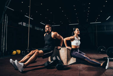 運動運動員和女運動員在黑暗的體育館里一起鍛煉立方體