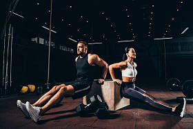 运动运动员和女运动员在黑暗的体育馆里一起锻炼立方体