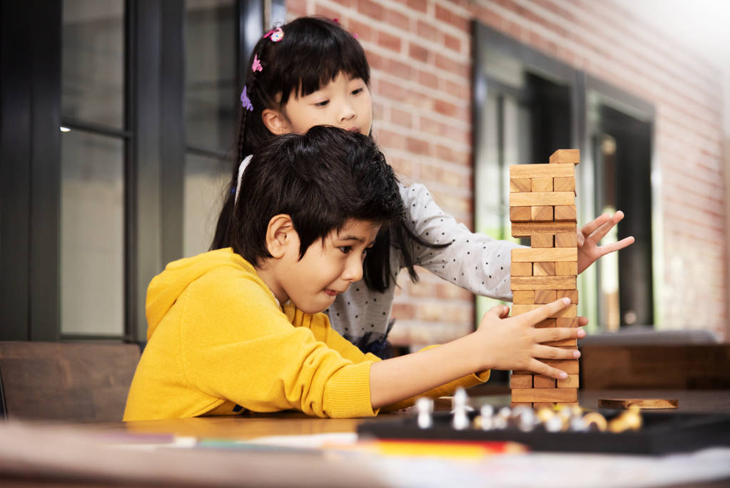 亚洲孩子们一起在学校的教室里玩木块堆游戏 亚洲孩子们一起在学校的教室里玩木块堆游戏