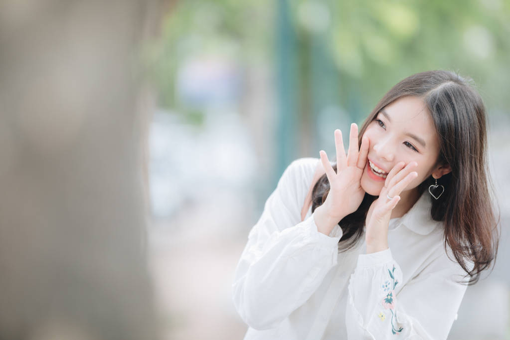 亚洲女孩的肖像与白衬衫和裙子大喊大叫在户外城市复古电影风