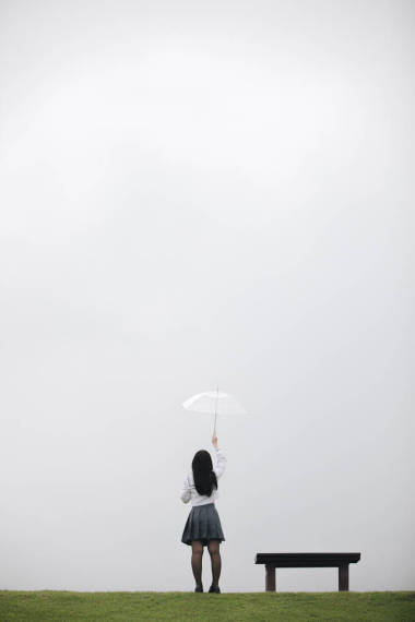 在雨中漫步在自然人行道上的亞洲學(xué)校女孩肖像