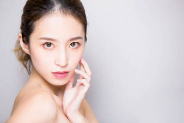 在灰色背景的美容皮膚護理婦女