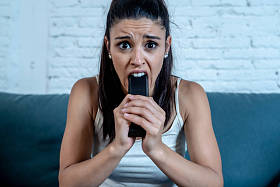 美丽的拉丁女人害怕害怕和厌恶, 而看电视恐怖电影坐在沙发上独自在客厅在家