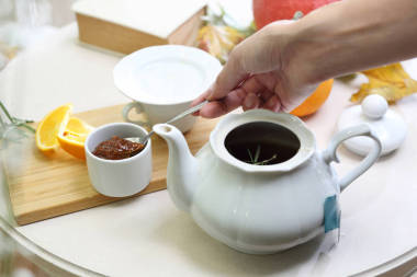 茶配李子果醬。一個女人在壺里泡芳香茶