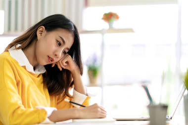 年輕迷人的亞裔女學(xué)生坐在桌旁，用手記、意念、日記或草圖等方式，在家里或圖書館的筆記本上構(gòu)思和書寫帶有版權(quán)空間的日記