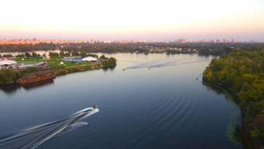 空中無人機(jī)飛行: 人們騎在船后面的木板上