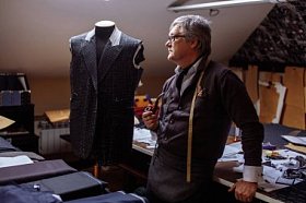 成熟的裁缝工作与切割模式在缝纫车间在傍