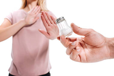 婦女拒絕不健康的鹽查出的白色的裁剪圖像