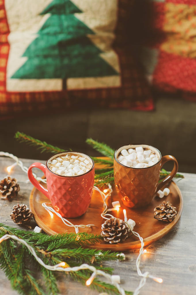 两大杯热可可和棉花糖与圣诞灯仿古木制的桌子上。舒适的冬天节日的家居理念 两大杯热可可和棉花糖与圣诞灯仿古木制的桌子上。舒适的冬天节日的家居理念