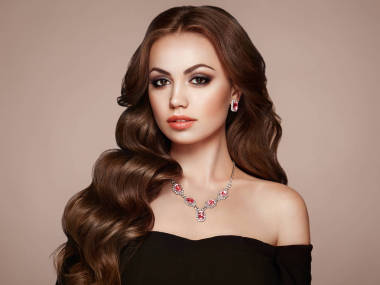 布魯內(nèi)特長健康卷曲頭發(fā)的女孩。愛與美。美麗的模特和華威發(fā)型?；瘖y和黑衣