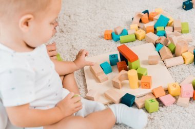 在可愛的幼兒玩五顏六色的立方體的側(cè)視圖