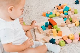 在可爱的幼儿玩五颜六色的立方体的侧视图