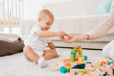 可愛的幼兒玩五顏六色的立方體在托兒所房間