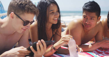 享受陽光明媚的海灘的年輕多民族朋友的肖像