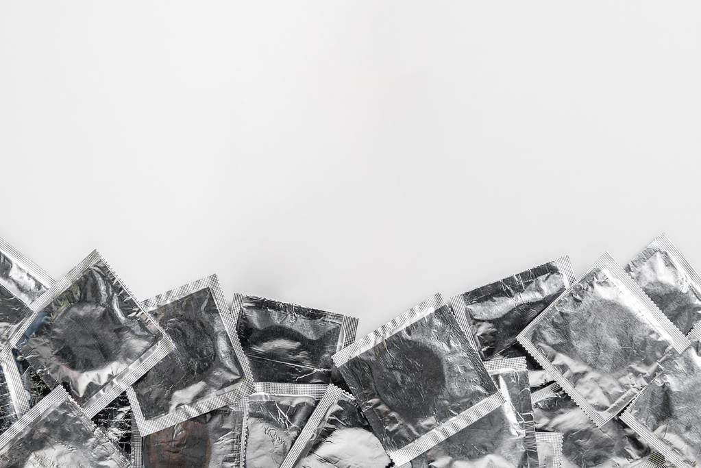 查出的银色避孕套在白色背景与拷贝空间