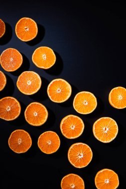 在黑色背景上安排的切橘子的完整框架一半